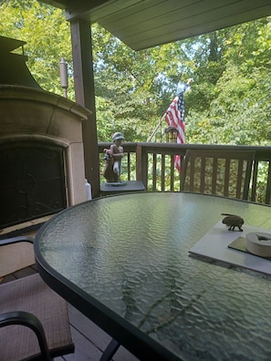 A covered outdoor area with a glass table, a barbecue grill, and an American flag. - 3-bedroom house in charming Louisville with cool AC breeze (Louisville)