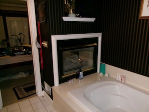 A bathroom with a bathtub, a mirror, and a window. - 3-bedroom house in charming Louisville with cool AC breeze (Louisville)