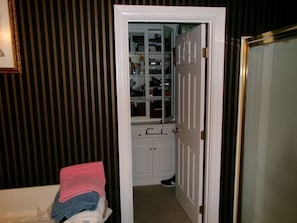 A room with a white door, a mirror, and a closet with hanging clothes. - 3-bedroom house in charming Louisville with cool AC breeze (Louisville)