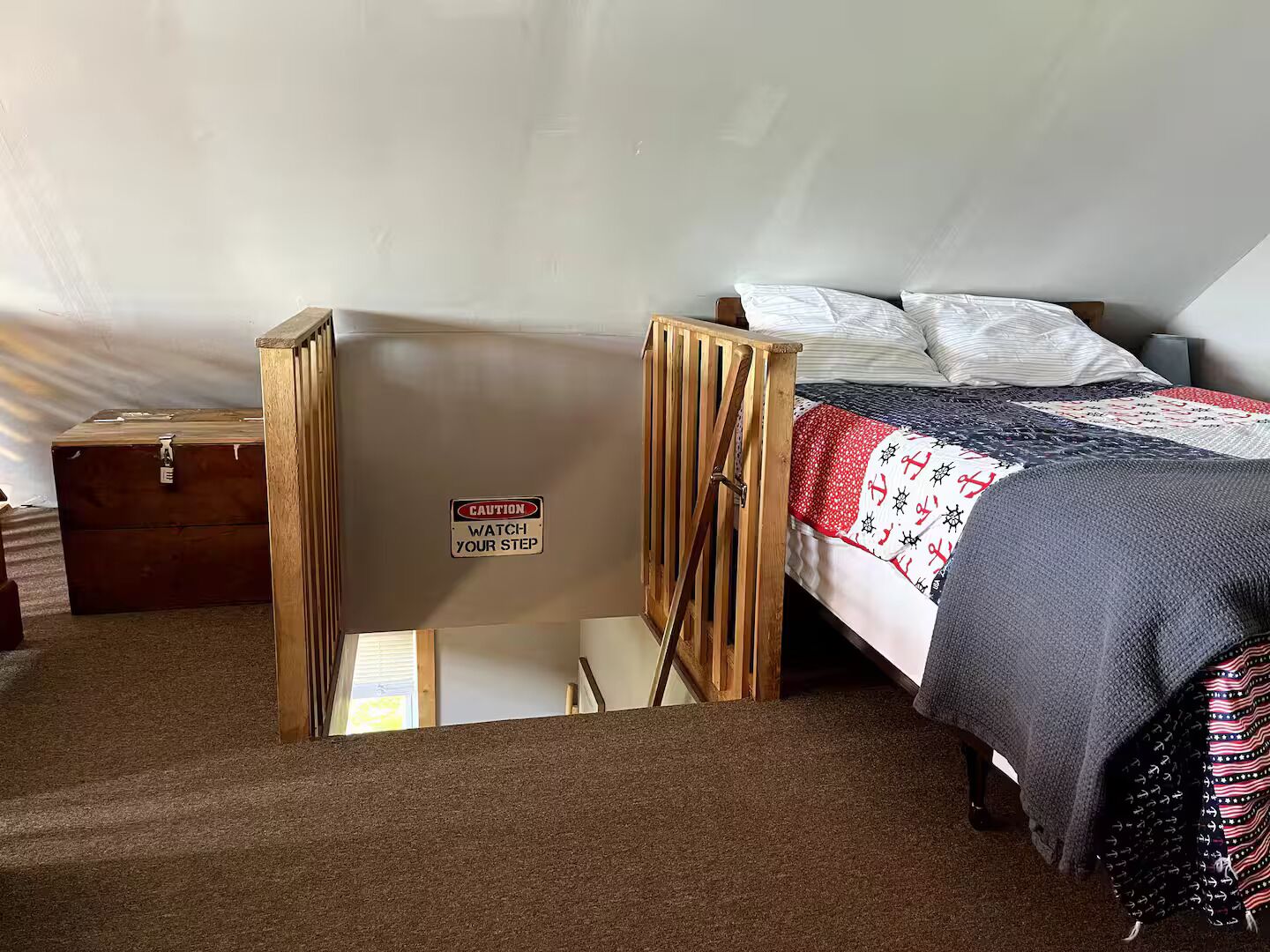 A bedroom with a bunk bed, a caution sign, a wooden chest, and a carpeted floor.