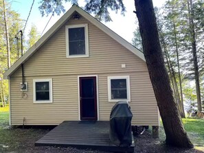 A single-story house with a front door, two windows, and a covered outdoor area.