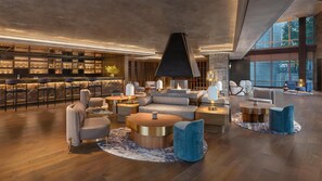 Un área de descanso moderna con bar, asientos y chimenea.