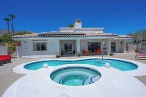 Ein Haus mit Swimmingpool, überdachter Terrasse und Bergblick.