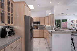 A modern kitchen with built-in appliances, wooden cabinets, and a granite countertop. - Villa Toscana - 3BR +Den w/ Pool, Spa & Valley Views (Palm Springs)