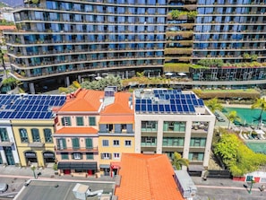 A multi-story building with balconies, solar panels, and a pool area. - Imperatriz 2D by Homie (Funchal)