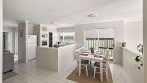 Eine moderne Küche mit Essbereich, Kühlschrank, Backofen und Mikrowelle.