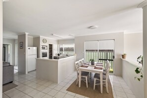 Eine moderne Küche mit Essbereich, Kühlschrank, Backofen und Mikrowelle.