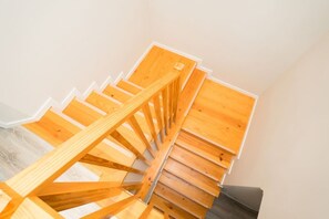 A wooden staircase with a handrail, leading to an upper floor. - Once Upon A Haven Setubal (São Lourenço)