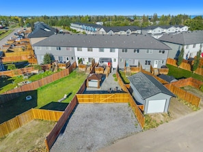 Un quartier résidentiel comprenant plusieurs maisons, une cour clôturée et un petit abri de jardin.