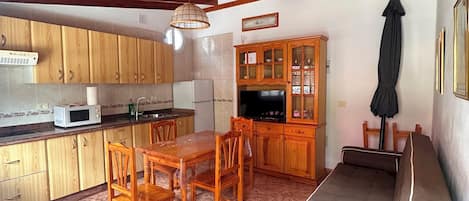A compact living space with a kitchen, dining area, and a sofa.