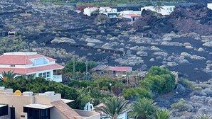 A coastal landscape with buildings, vegetation, and a prominent mountain. - El Rinconcito Home in Tamaduste 5 Min from Beach (Tamaduste)