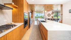 Una cucina moderna con isola centrale, mobili in legno e vista su un'area pranzo.