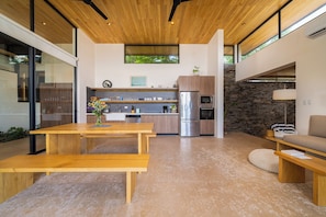 Una cocina moderna con una isla central, electrodomésticos integrados y una pared decorativa de piedra.