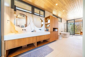 Une salle de bain moderne avec deux vasques, des meubles en bois et un grand miroir.