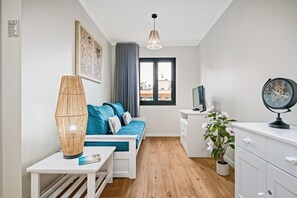 A modern bedroom with a bed, bedside table, lamp, TV, and a potted plant. - Imperatriz 2D by Homie (Funchal)