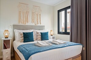 A hotel room with a bed, bedside tables, a window with curtains, and wall decor. - Imperatriz 2D by Homie (Funchal)