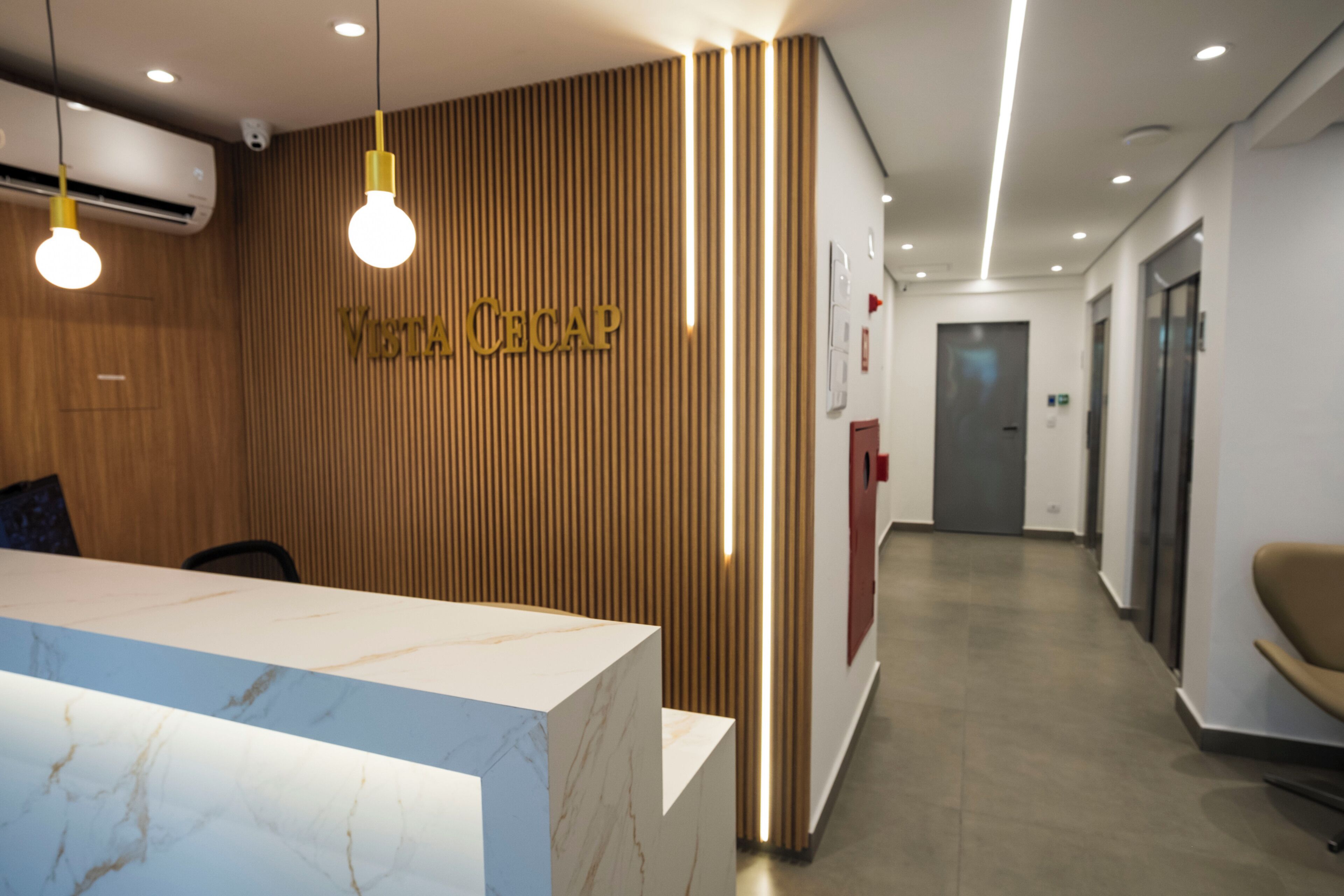 Una recepción con un panel de madera en la pared y el nombre 'VISTA CECAP' en la parte superior.