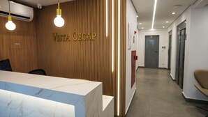 A reception desk with a wooden panel wall and the name 'VISTA CECAP' above it. - Vista Cecap (Guarulhos)
