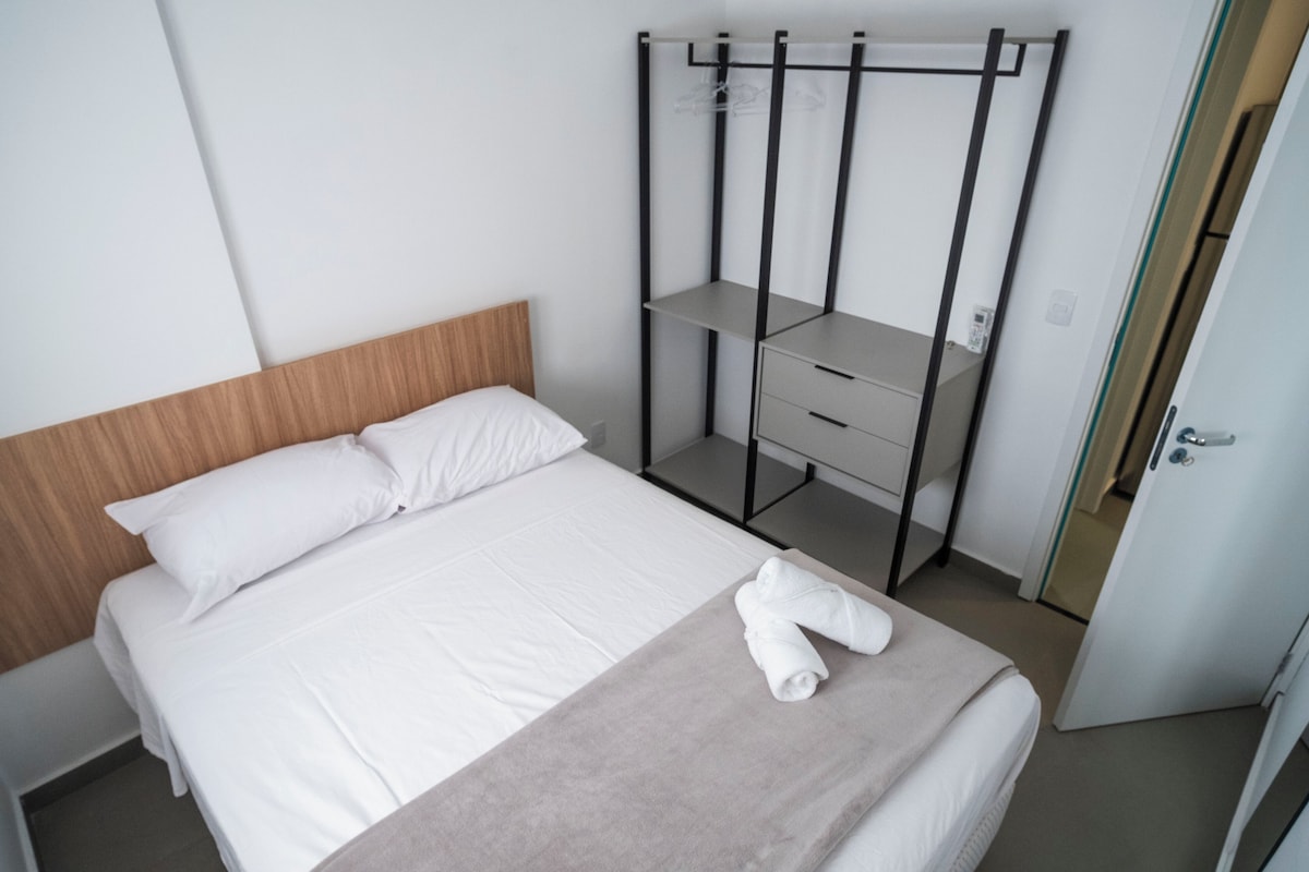 Hotellihuone, jossa on sänky, työpöytä ja vaatekaappi.