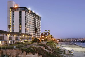 Ein Hochhaus-Hotel mit mehreren Etagen, Blick auf den Strand und einer gut beleuchteten Fassade.