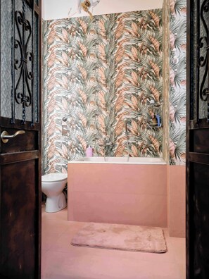 Une salle de bain avec des toilettes, un lavabo et une baignoire.