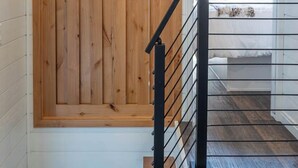 A wooden door with a black metal railing in a hallway. - Frieden Saugatuck (Saugatuck)