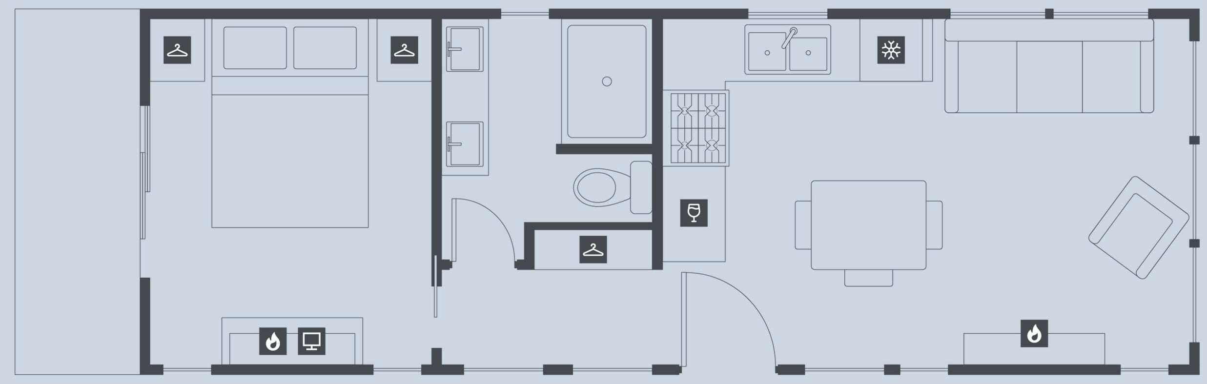 Un plan d’étage d’hôtel comprenant un grand espace de vie central, une salle à manger, une cuisine et une salle de bain.