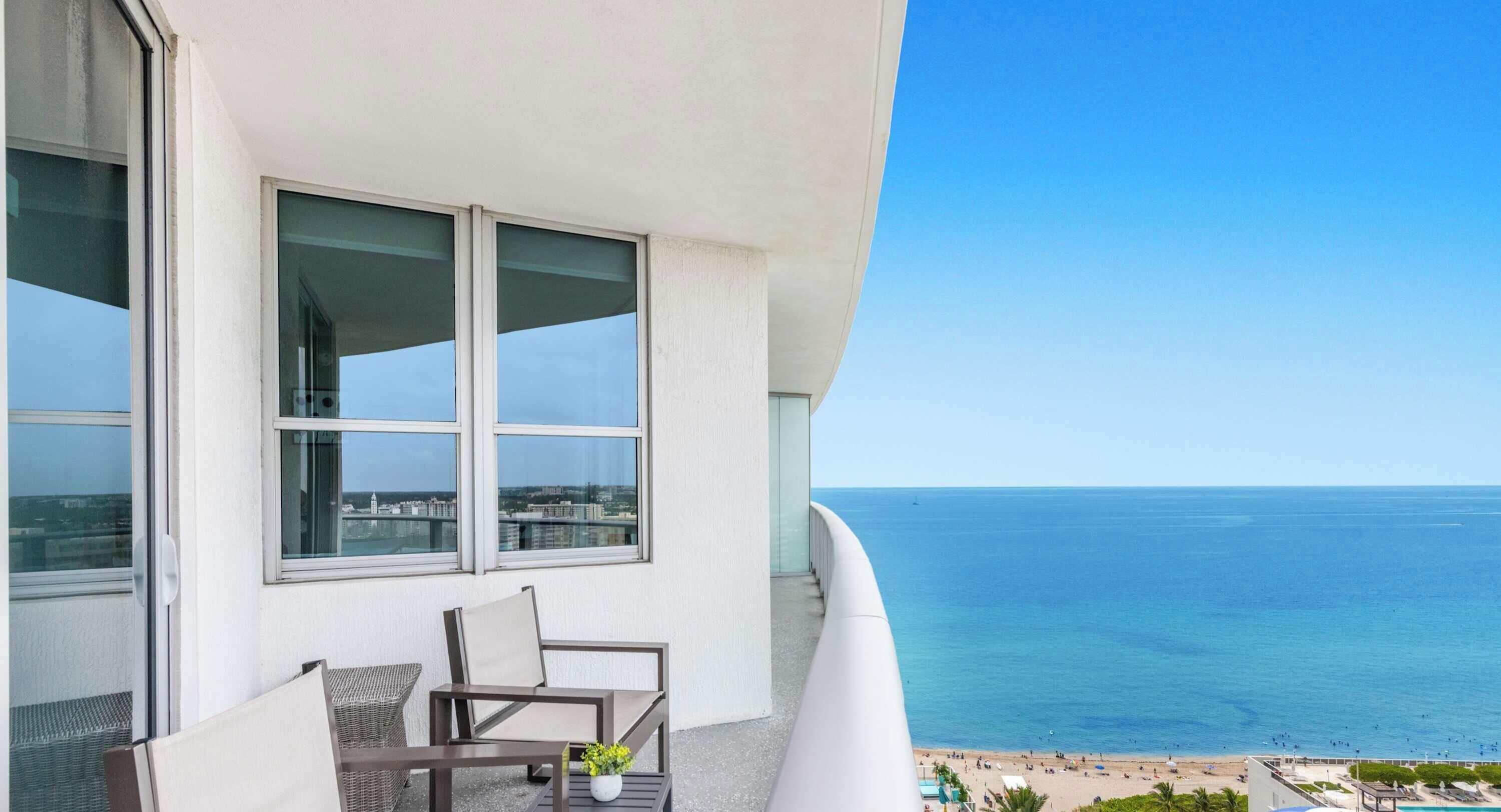 Een balkon met uitzicht op zee en een strand.