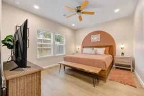 A bedroom with a bed, a ceiling fan, a TV, and a window with blinds. - New! Modern FamGetaway near BigRivers, Sleeps 10 (Porter Heights)