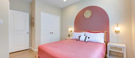 A bedroom with a bed, a ceiling fan, two bedside tables, and a nightstand.