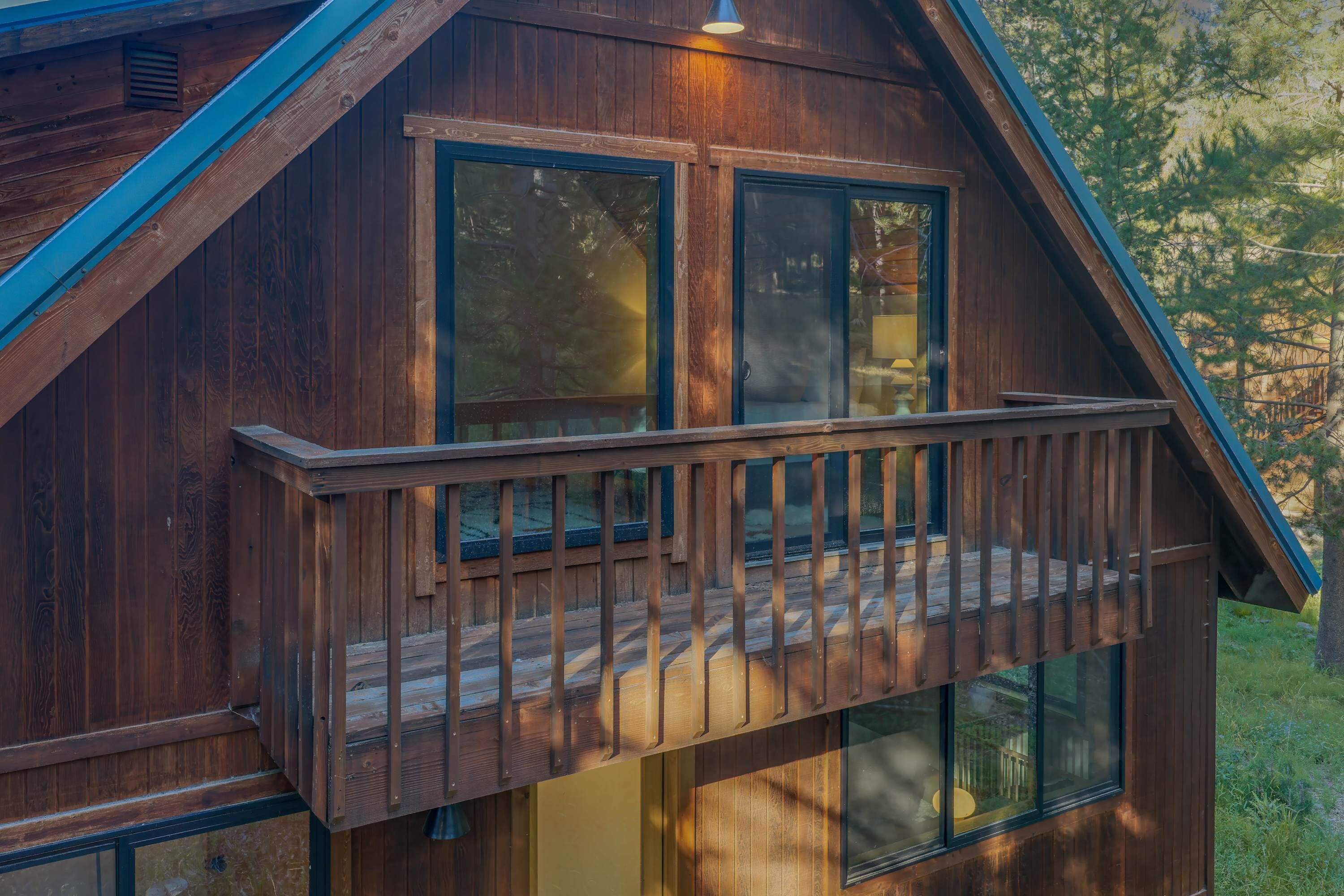 A wooden cabin with a balcony and large windows.
