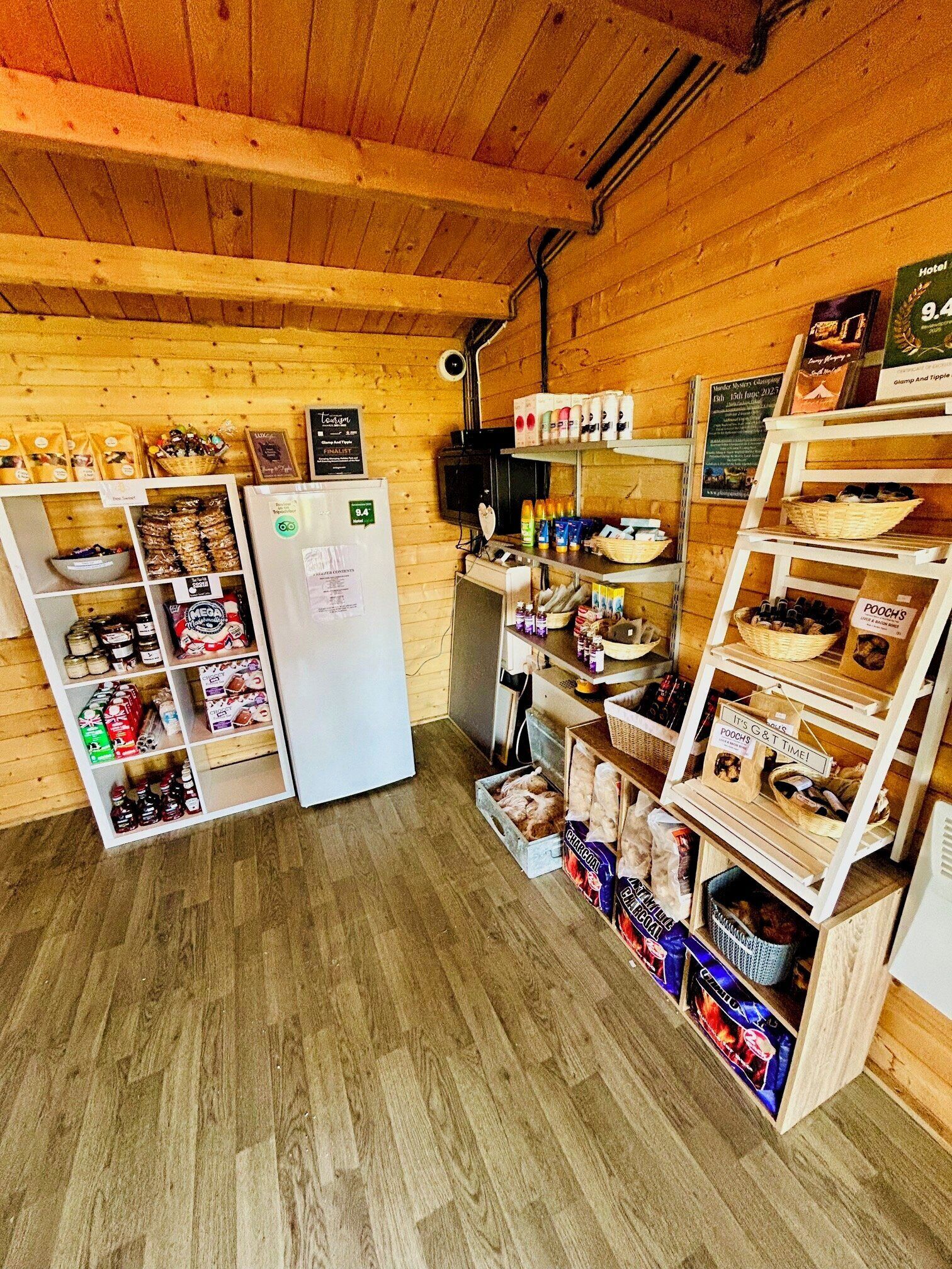 A wooden interior with a refrigerator, shelves stocked with snacks, and a sign indicating a 9.4 rating.