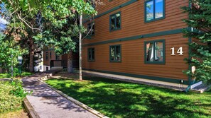 A two-story building with a number 14 on the side, a front porch, and a pathway leading to the entrance. - Falls & Firs by Avantstay Mtn Views + Balcony Trailheads + Ski Bus (Vail)