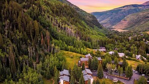 A mountainous area with dense forests and a cluster of buildings with multiple stories, likely a resort or lodge. - Falls & Firs by Avantstay Mtn Views + Balcony Trailheads + Ski Bus (Vail)