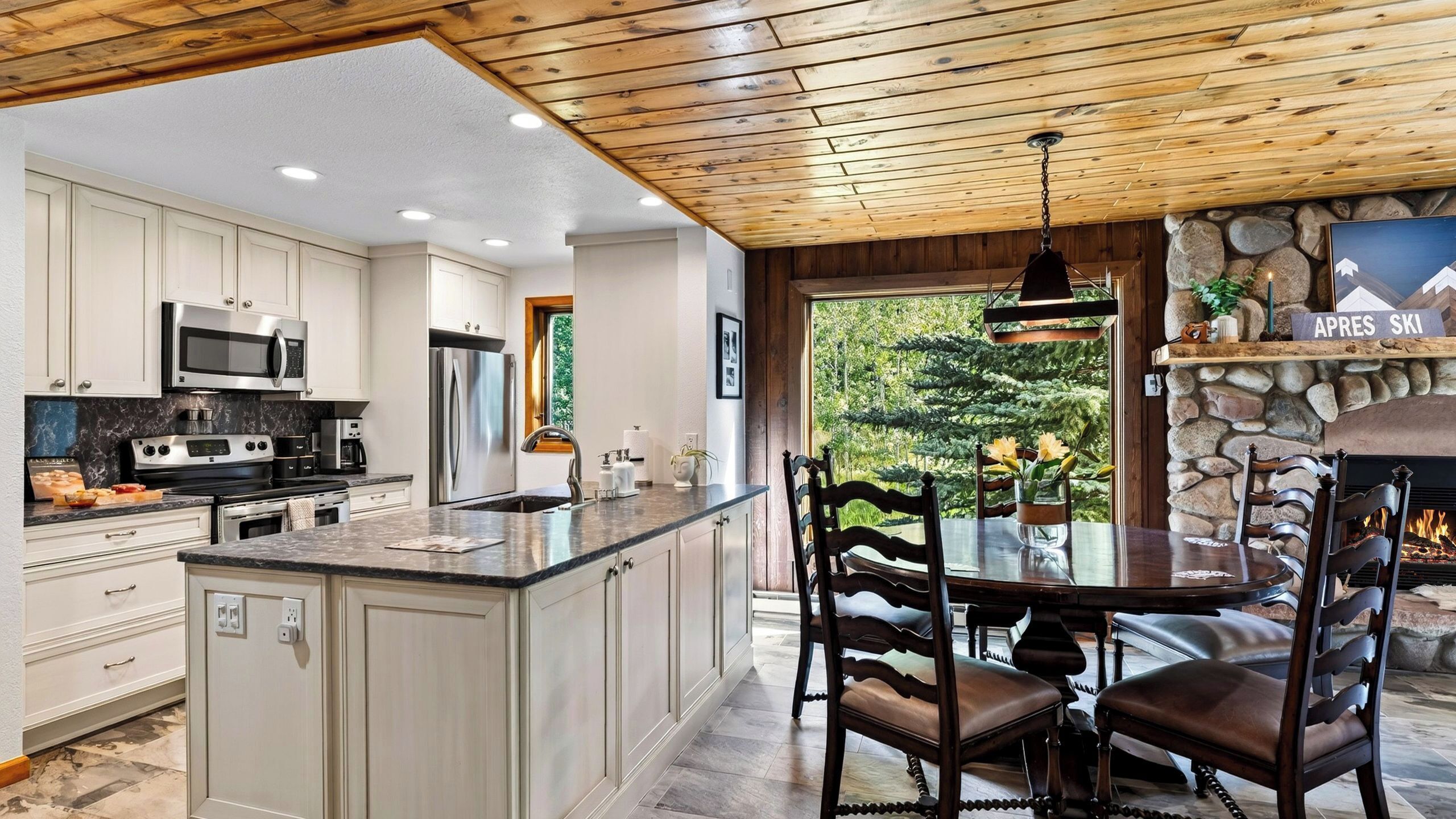 A modern kitchen with white cabinetry, stainless steel appliances, and a large island.