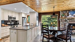 A modern kitchen with white cabinetry, stainless steel appliances, and a large island. - Falls & Firs by Avantstay Mtn Views + Balcony Trailheads + Ski Bus (Vail)