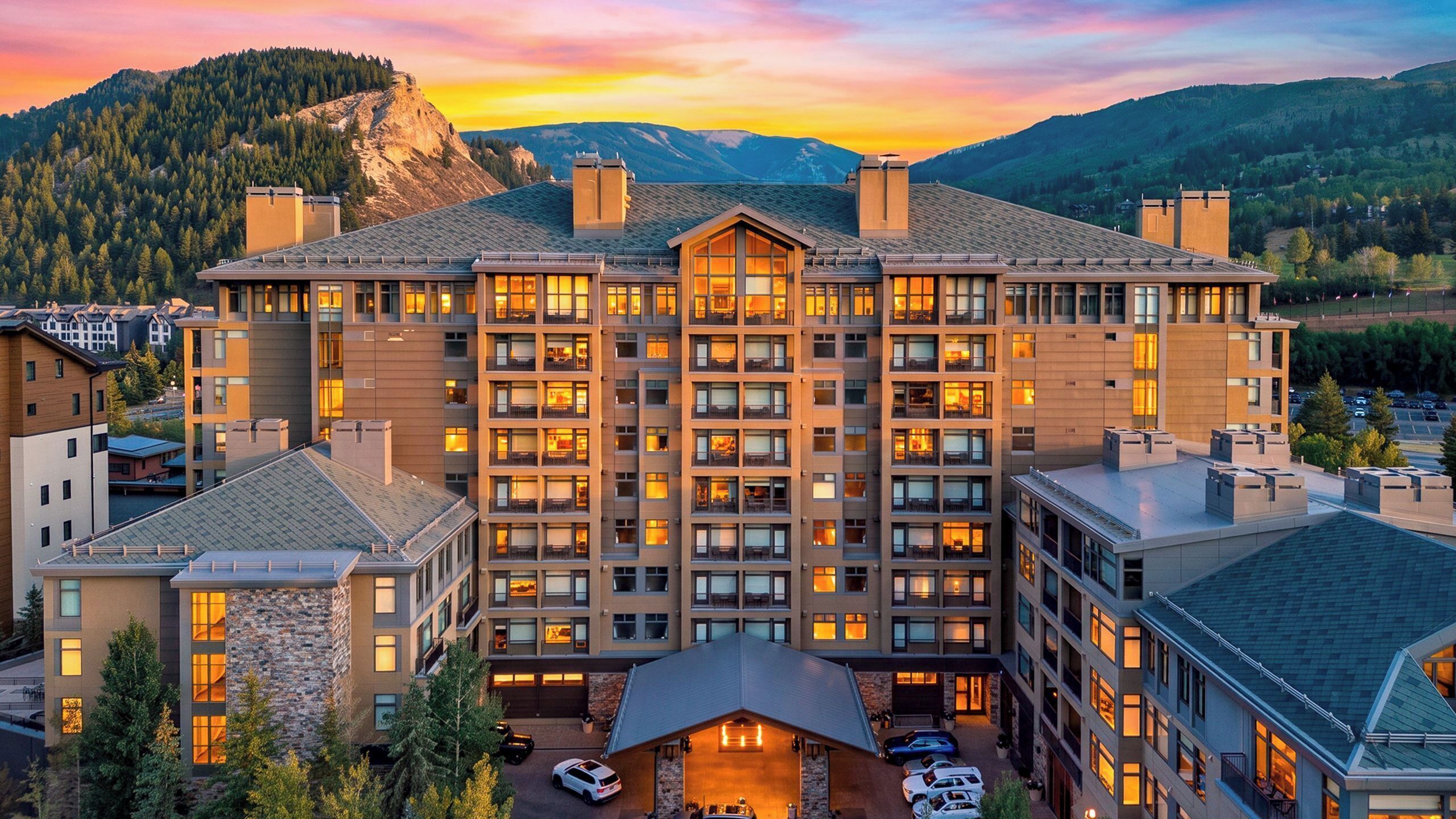 A multi-story hotel with a central courtyard, surrounded by mountainous terrain.