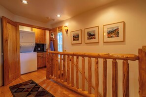 A kitchen with wooden cabinets, a white refrigerator, and a stove. There are three framed pictures on the wall. - Tahoe Village Condo | Walk to Heavenly Stagecoach (Stateline)