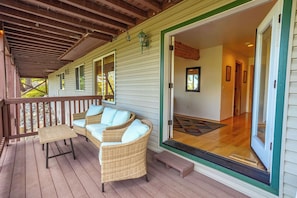 A covered porch with wicker furniture and a wooden table. - Tahoe Village Summit Escape (Stateline)
