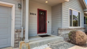 A residential house with a red door, number 2824, and a front porch with steps.