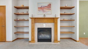 A room with a fireplace, wooden shelves, and a painting on the wall. - Evergreen Haven - Spacious Retreat Near the Best of Eugene (Eugene)