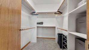 A walk-in closet with wooden doors, a hanging rod, and shelves. - Evergreen Haven - Spacious Retreat Near the Best of Eugene (Eugene)