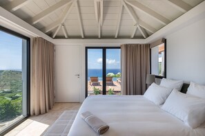 A hotel room with a large bed, a view of the ocean, and a balcony. - Villa Scarlett (4 bedrooms) (Saint Barthélemy)