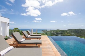 A poolside area with lounge chairs and a view of the ocean. - Villa Scarlett (2 bedrooms) (Saint Barthélemy)