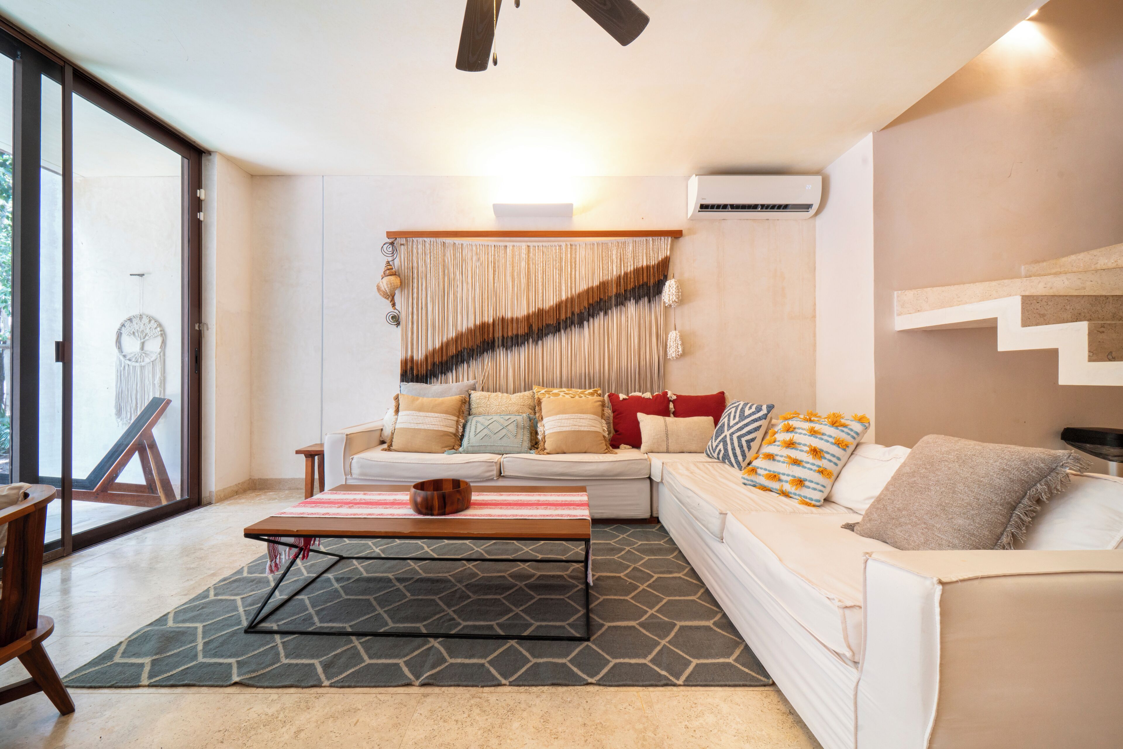 A modern living room with a sectional sofa, a coffee table, and a patterned rug.