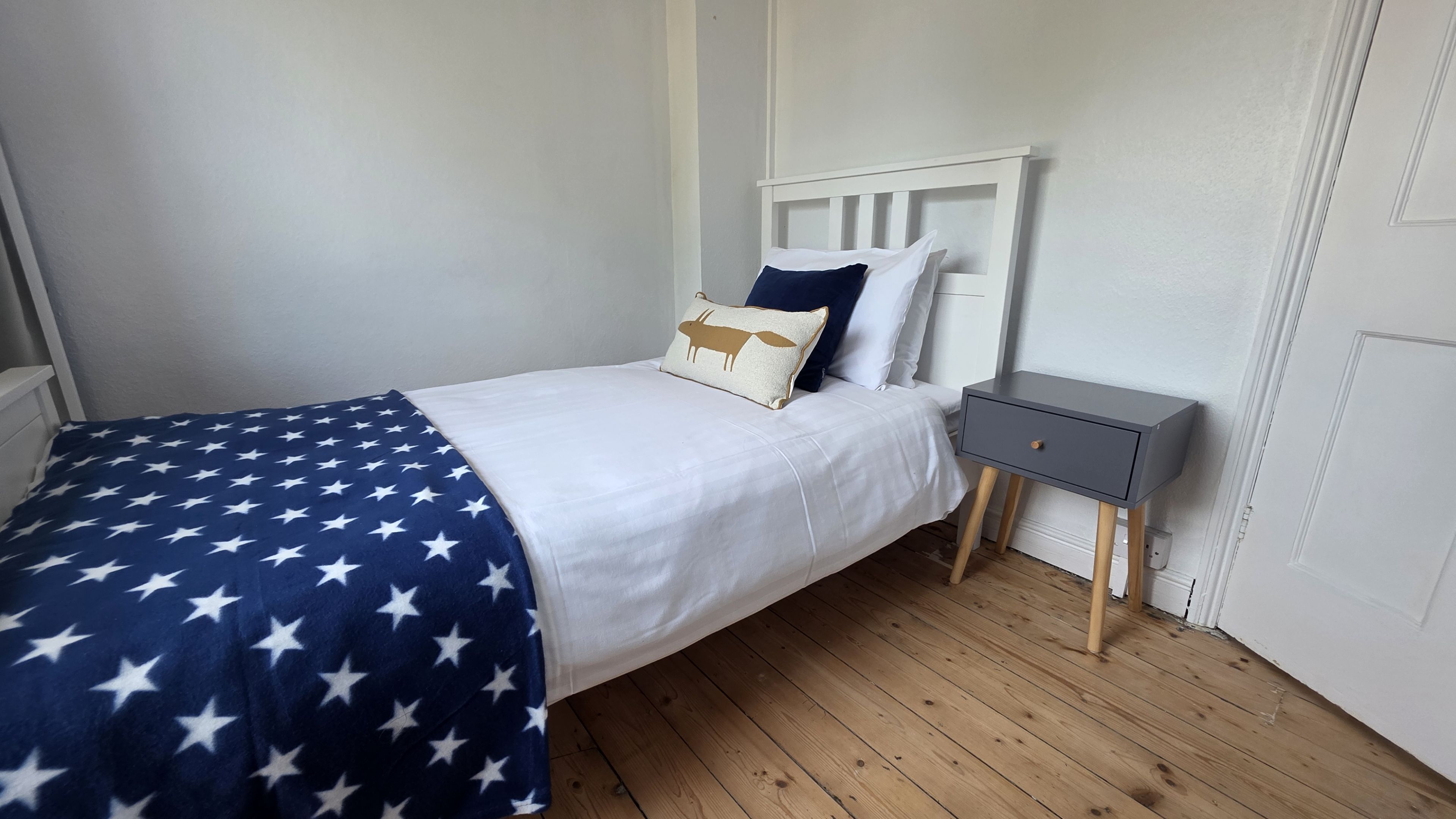 Une chambre à coucher avec un lit, une table de chevet et une commode.