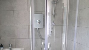 A modern bathroom with a glass-enclosed shower, a sink with a soap dispenser, and a cabinet with handles. - West Acre Cottage - sleeps 5 guests in 3 bedrooms (Westacre)