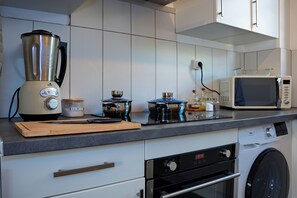 A modern kitchen with a built-in oven, microwave, and a coffee maker. - 10 minutes from the beach and Nausicaá, 76 m² apartment + motorcycle garage available upon request. (Boulogne-sur-Mer)