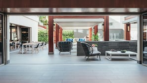Un espace extérieur moderne aménagé avec des tables et des chaises, un foyer et une vue sur le paysage environnant.