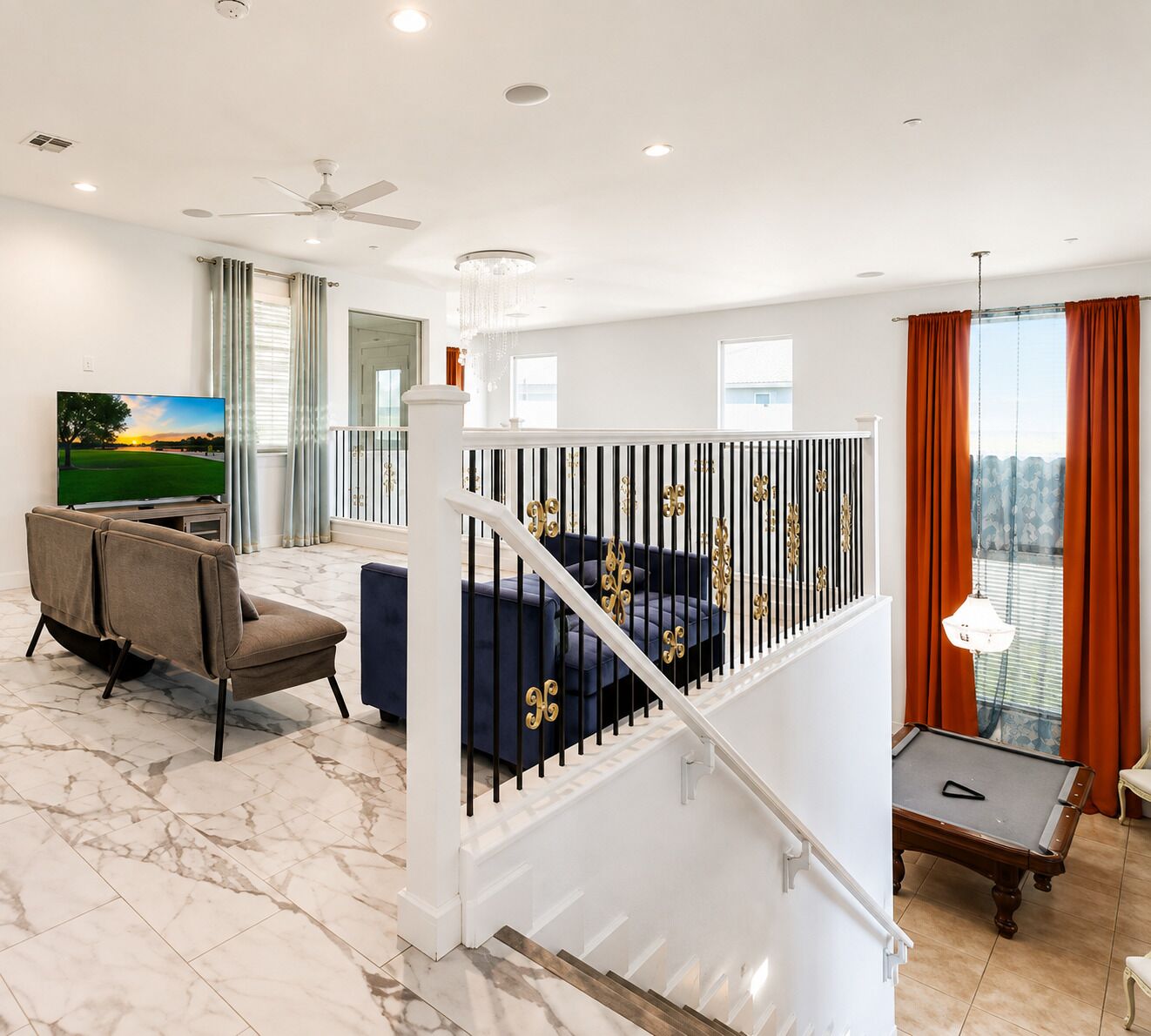 Un salon moderne doté d’un téléviseur à écran plat, d’un canapé, d’une table de billard et d’un escalier avec une rampe.